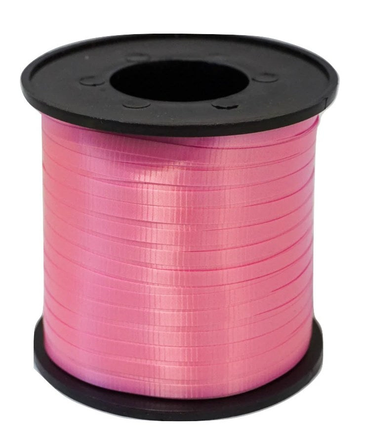 Spool of neon pink curling ribbon with a shiny, smooth texture on a black plastic core.