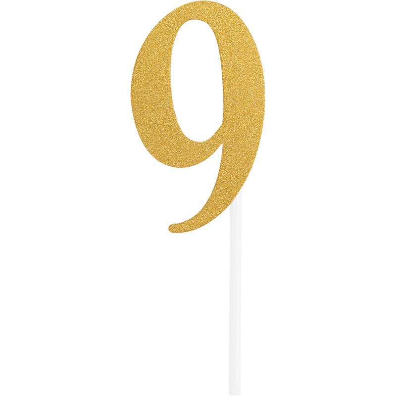 Gold glitter number 9 cake topper with a white stick base.