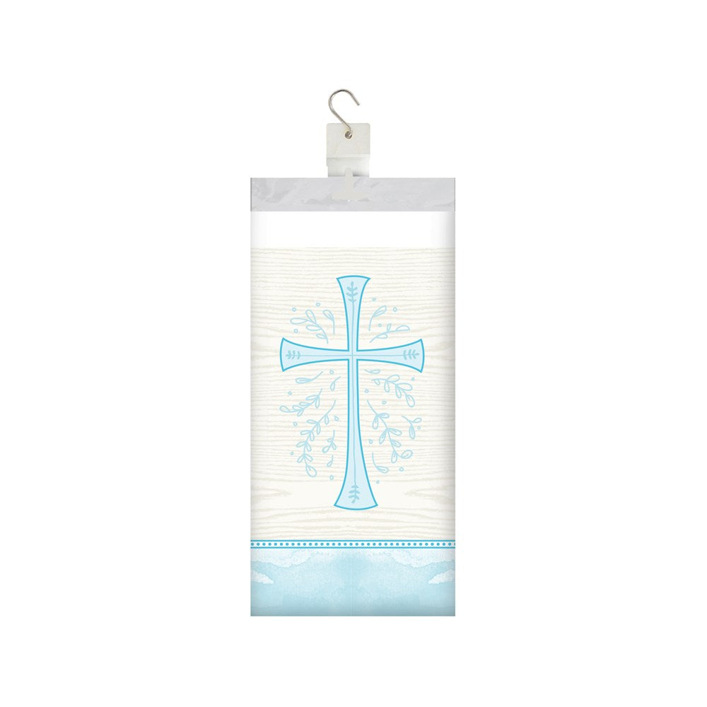 White plastic tablecover with a blue cross and decorative floral accents, folded and packaged hanging on a hook.