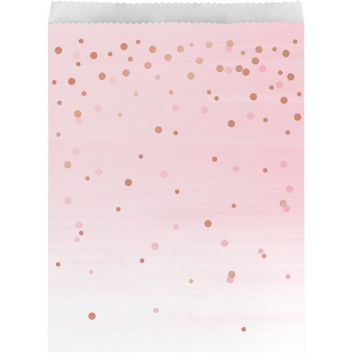 Pink gradient paper treat bag with metallic rose gold confetti dots, scalloped top edge.