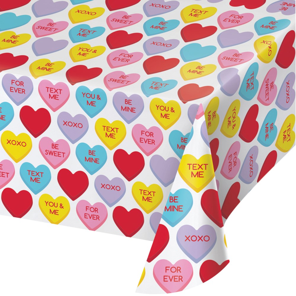 Plastic tablecover with colorful candy hearts featuring love messages on a white background.