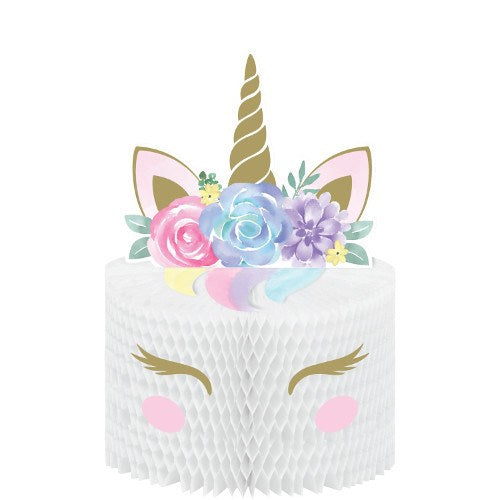 White honeycomb paper centerpiece shaped like a unicorn with gold horn, pastel floral crown, closed eyes, and pink cheeks.
