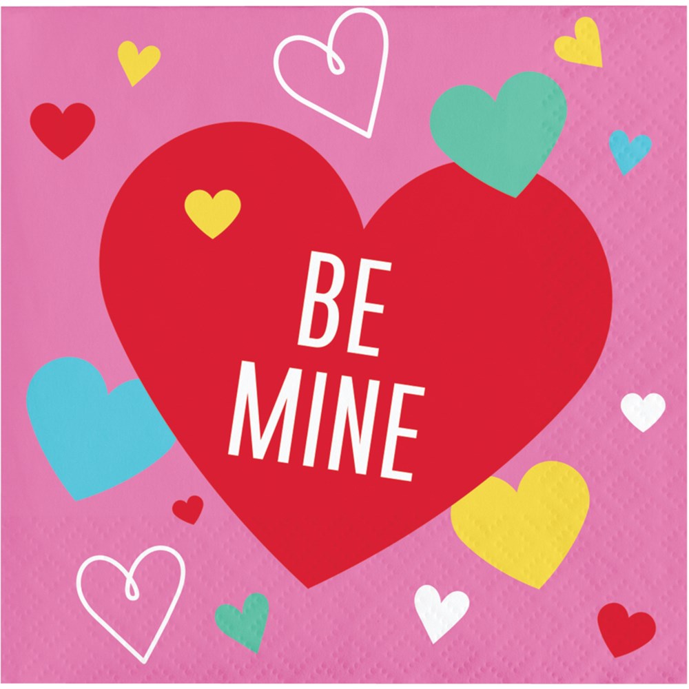 Pink paper napkin with a large red heart reading "Be Mine" surrounded by colorful hearts in yellow, teal, white, and red.