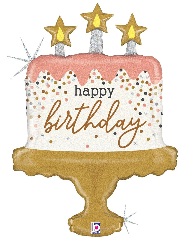 Holographic foil balloon shaped like a birthday cake with pink icing, gold confetti dots, three gold star candles, and.