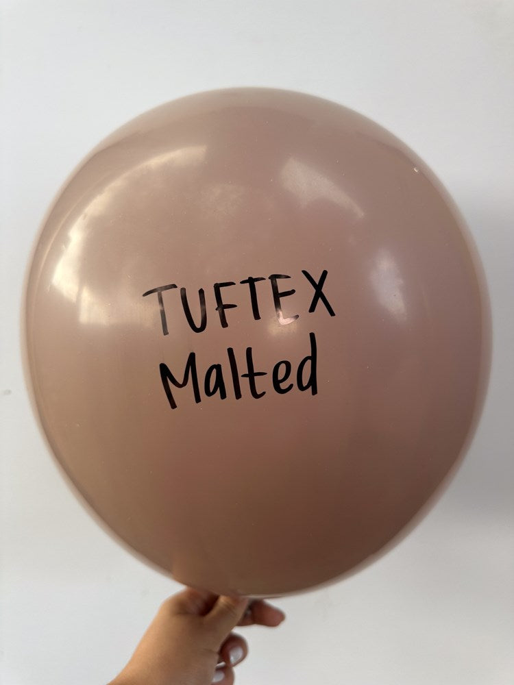 Round malt brown latex balloon with black "Tuftex Malted" branding, inflated and smooth surface.