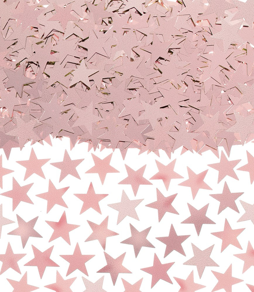 Loose rose gold metallic star-shaped confetti scattered on a pink surface.