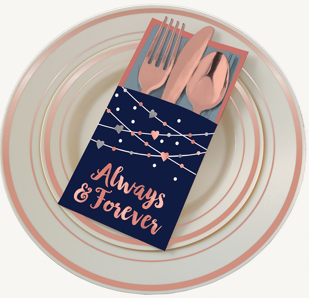 Navy blue paper cutlery holder with pink string lights design and "Always & Forever" text, holding rose gold plastic fork,.