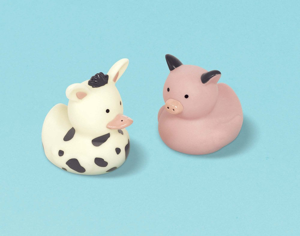 Two small rubber ducks designed as barnyard animals, one white with black spots and a cow face, the other pink with a pig.