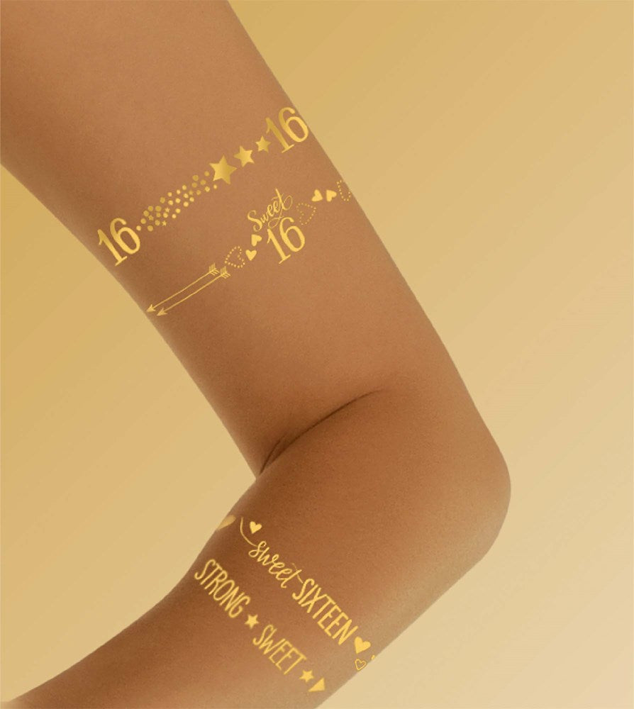 Set of gold metallic temporary tattoos with "16," stars, arrows, and "Sweet Sixteen" text on skin tone arm.