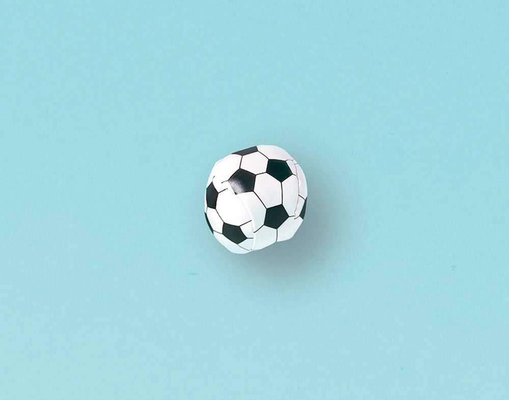 Small white and black pentagon-patterned squishy soccer ball toy against light blue background.