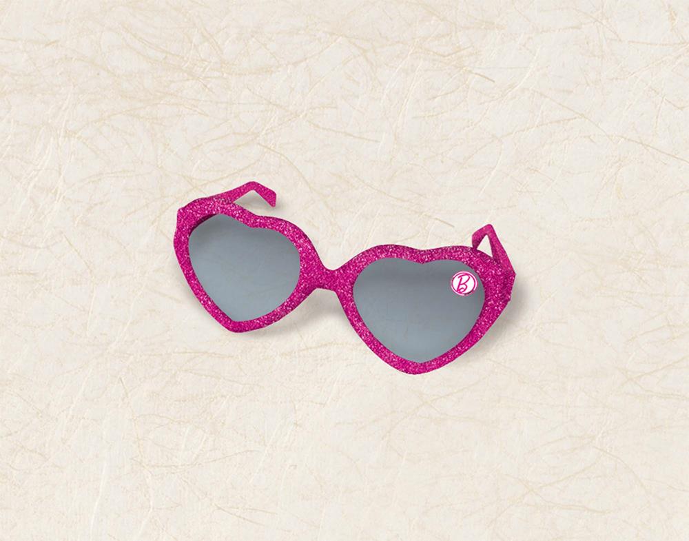 Pink glittery heart-shaped sunglasses with dark tinted lenses and Barbie logo detail.
