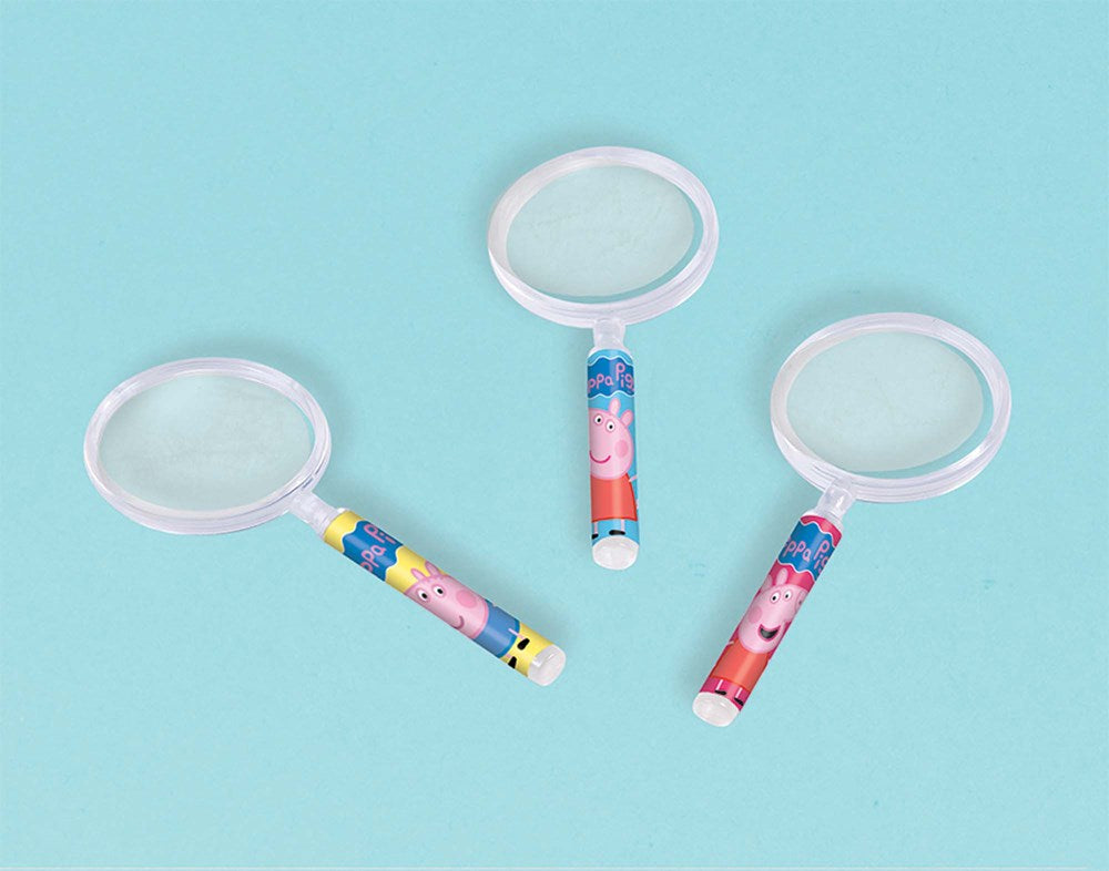 Three kids' magnifying glasses with Peppa Pig themed handles on a light blue background.