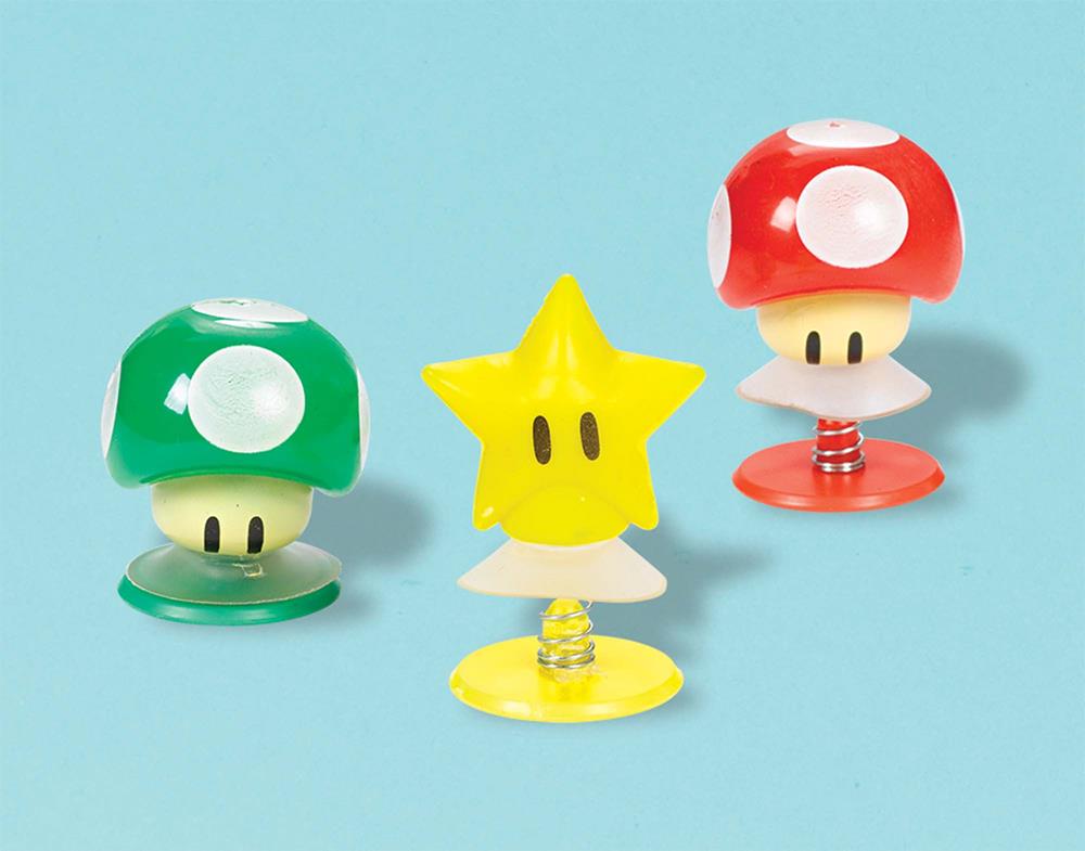 Set of three Super Mario pop-up toys featuring a green mushroom, yellow star, and red mushroom on spring bases.