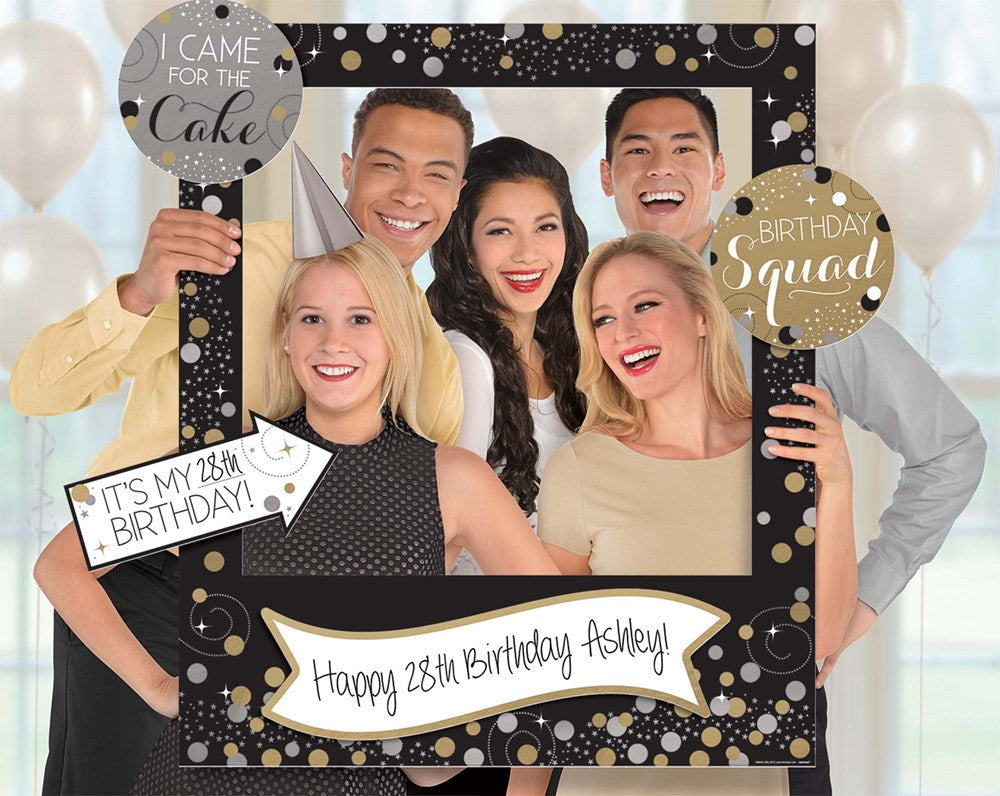 Giant black photo frame with gold, white polka dots, "Happy 25th Birthday Ashley" banner, four smiling adults holding.