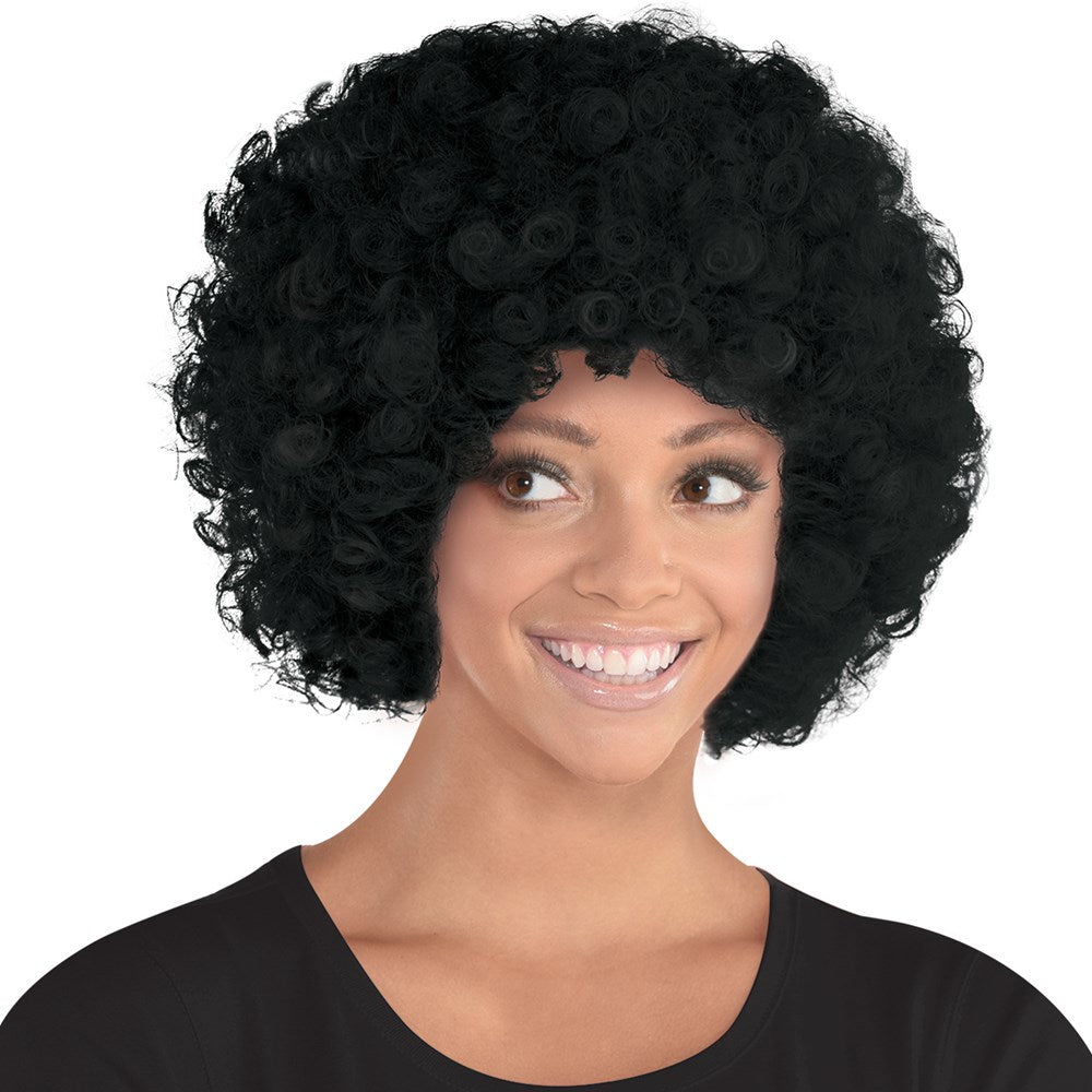 Black voluminous curly afro wig on a smiling woman with medium skin tone.