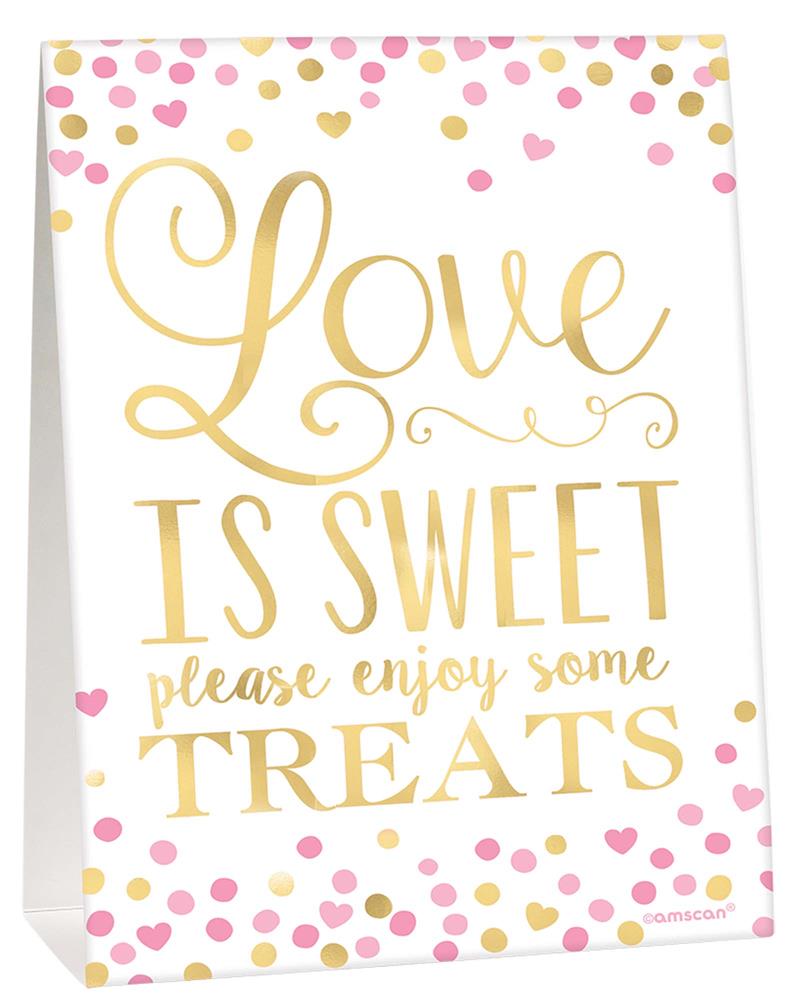 White tented buffet sign with gold and pink confetti dots, gold cursive and block text reading "Love is sweet please enjoy.