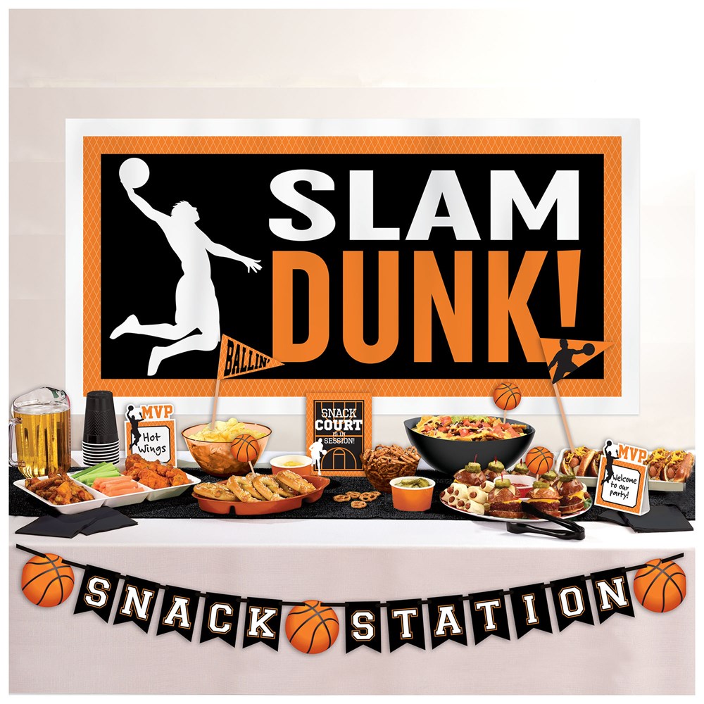 Black and orange basketball-themed buffet sign with "SLAM DUNK!" text and dunking player silhouette, decorated snack station