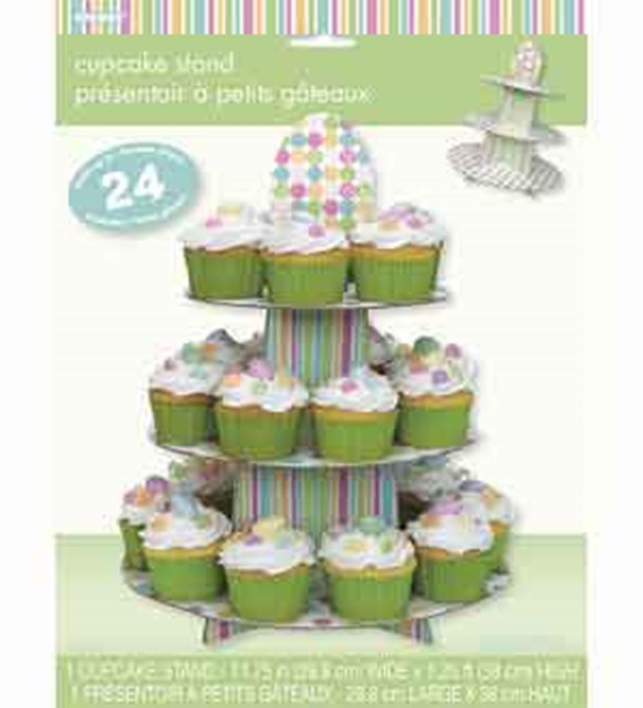 Three-tiered cupcake stand with pastel striped base and polka dot top, holding 24 cupcakes with white frosting and pastel.