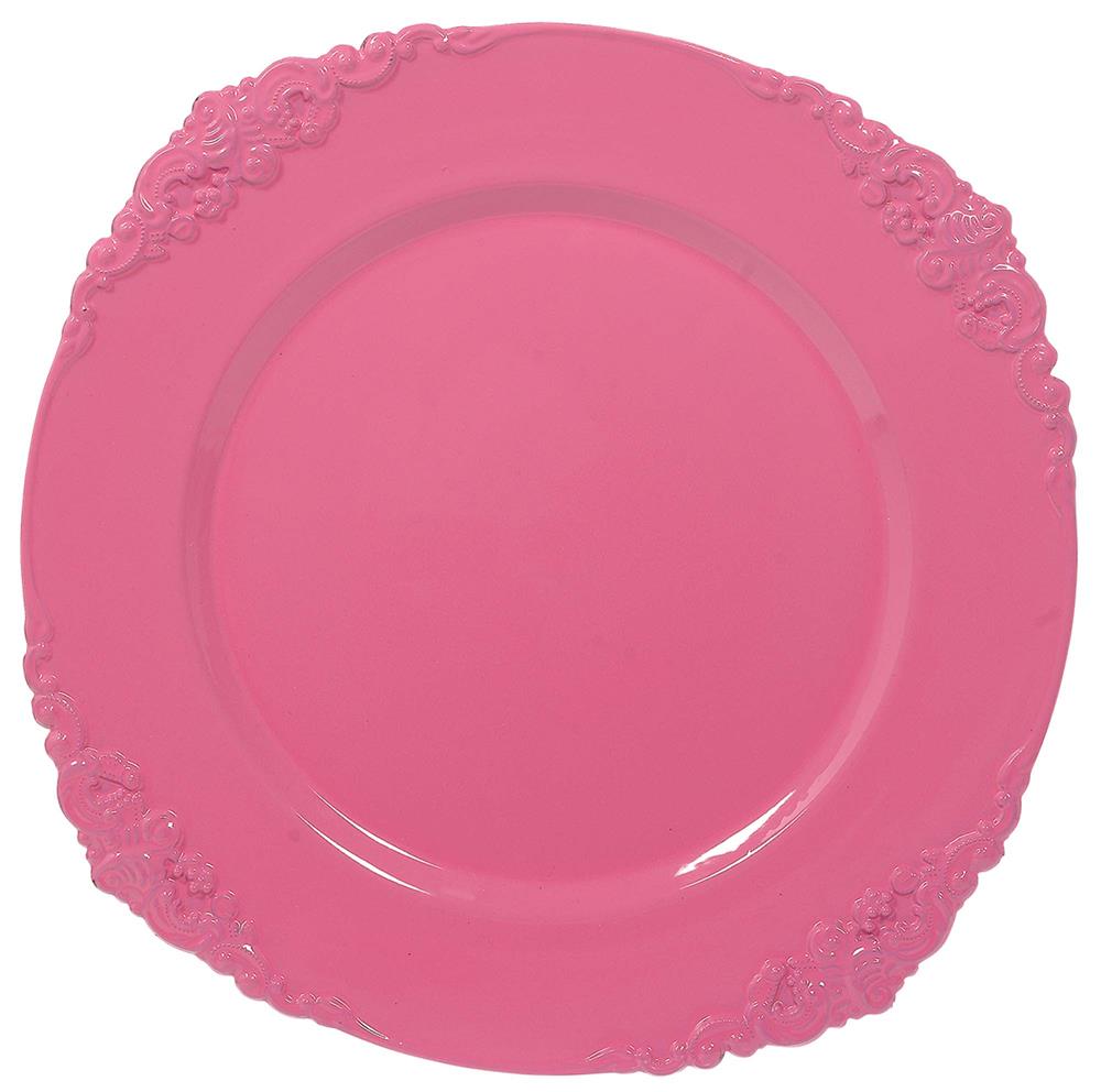 Pink plastic charger plate with scalloped edges and ornate floral scroll detailing around the rim.