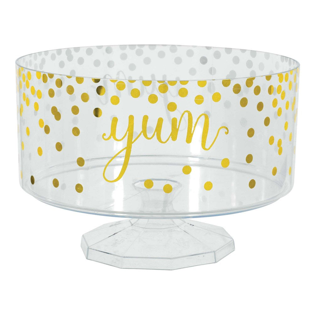 Clear plastic trifle bowl with gold polka dots and "yum" text on pedestal base.