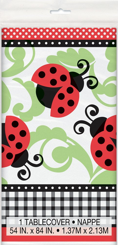Tablecover with large red ladybugs, black spots, and green swirling vine patterns on a white background with a red and black