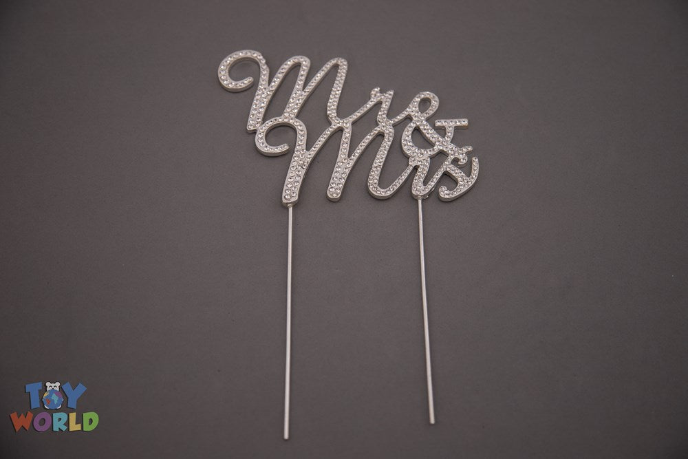 Silver rhinestone cake topper spelling "Mr & Mrs" in cursive with two long stems for insertion.