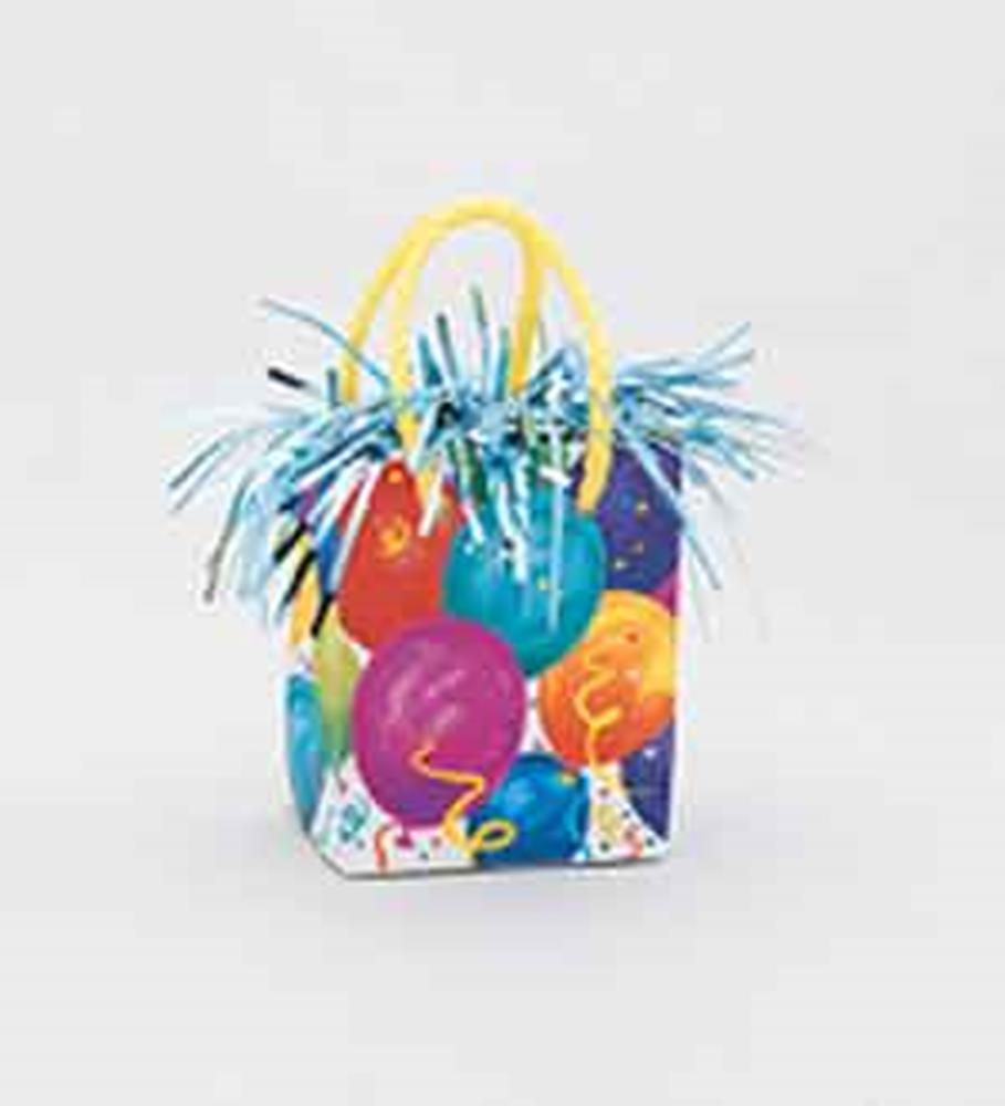 Small festive gift bag balloon weight with colorful balloon prints and metallic blue tassels, yellow handles.