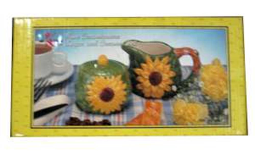 Ceramic teal sunflower creamer pitcher and matching sugar bowl with sunflower lids on blue tablecloth.