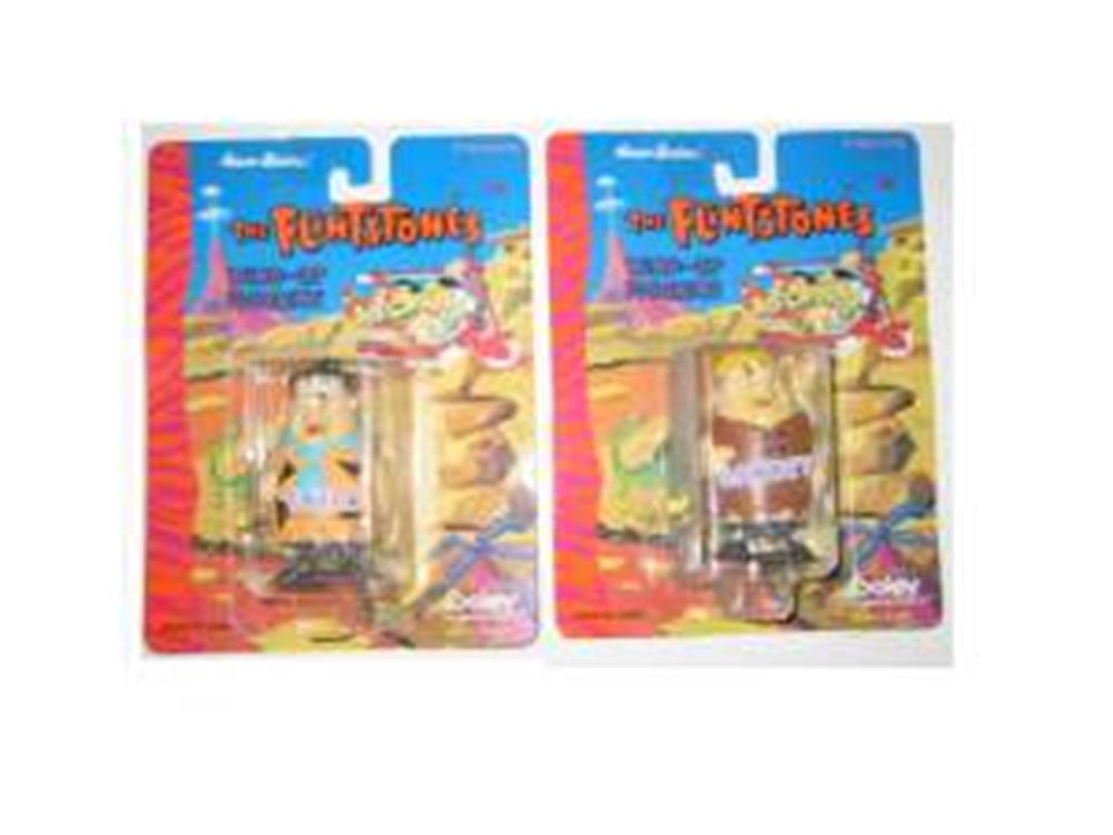Set of Flintstones Fred and Barney plastic party toys in colorful blister packaging with prehistoric background art.
