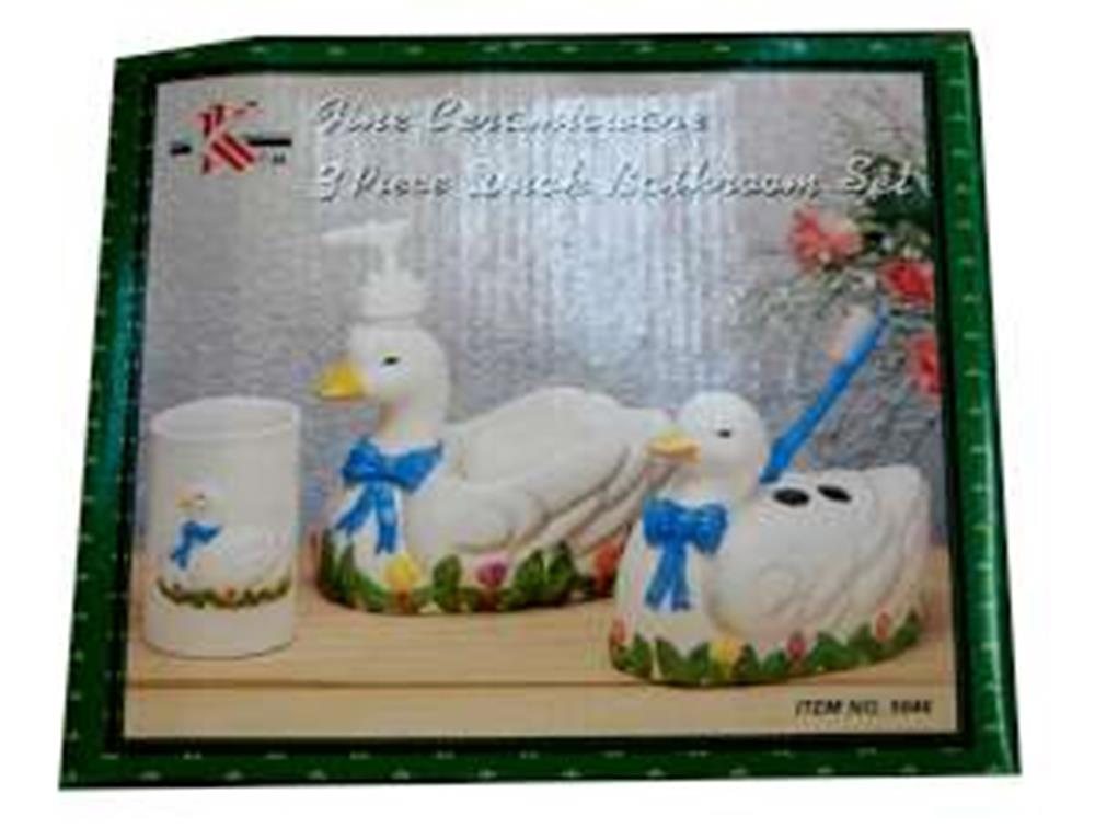 White ceramic duck bathroom set with blue bow accents, includes soap dispenser, toothbrush holder, and tissue box cover.