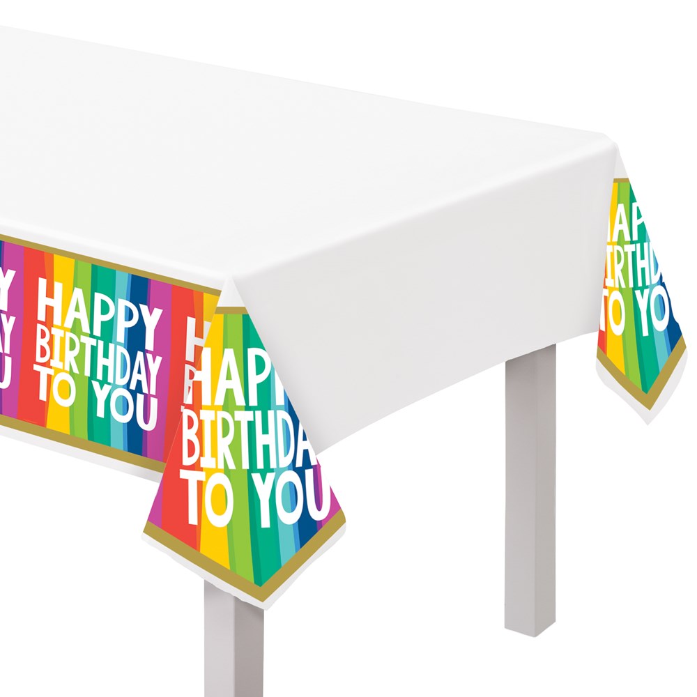 Rectangular plastic tablecover with vibrant rainbow-colored stripes and "Happy Birthday To You" text on the corners.