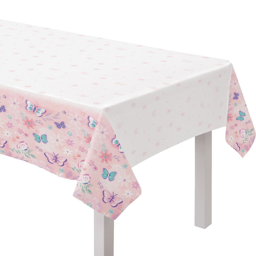 Pink plastic table cover with colorful butterfly prints and small scattered dots, rectangular shape.