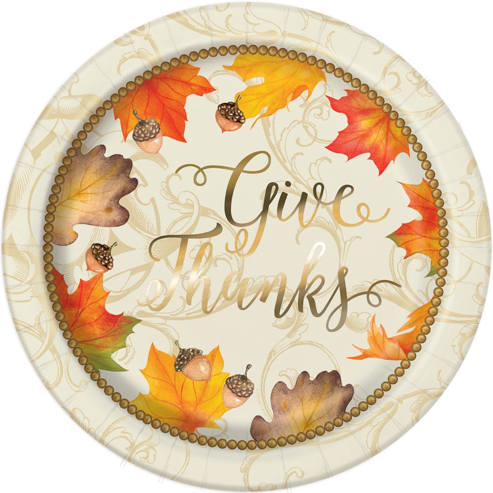 Round paper plate with gold foil "Give Thanks" text, decorated with colorful autumn leaves and acorns on a beige background.