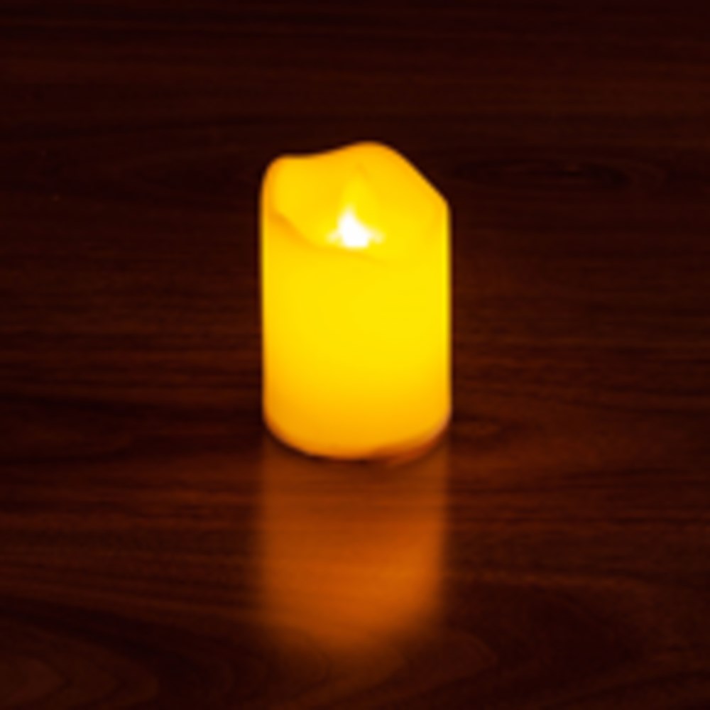 Small yellow LED candle with a flickering flame effect and smooth cylindrical shape.