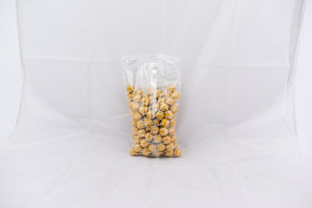 Clear plastic bag filled with shiny gold-coated round gumballs, 2-pound size.