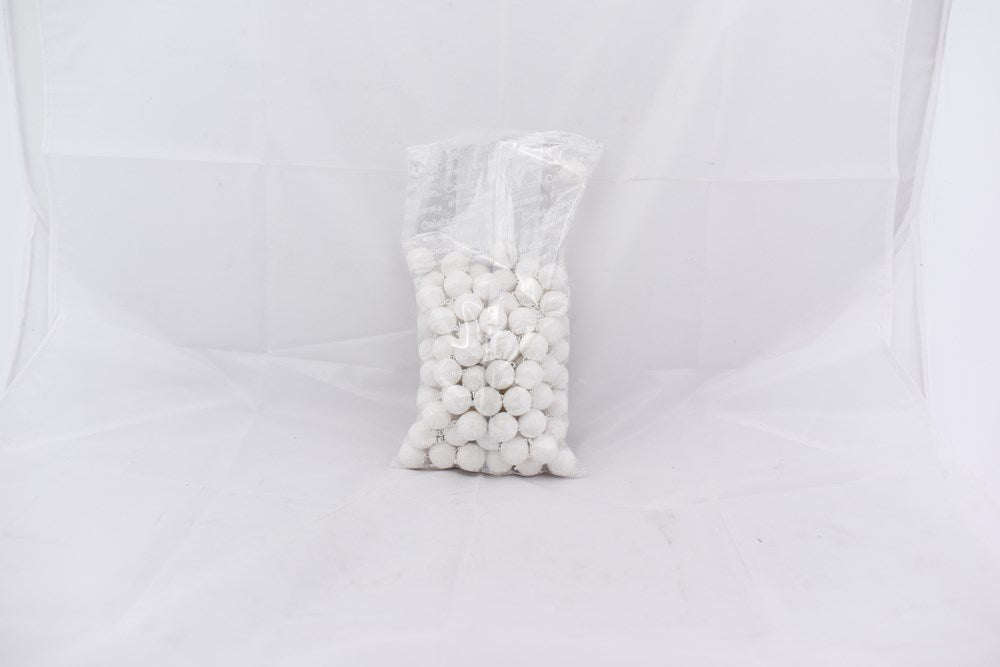 Clear plastic bag filled with small, round white gumballs on white background.