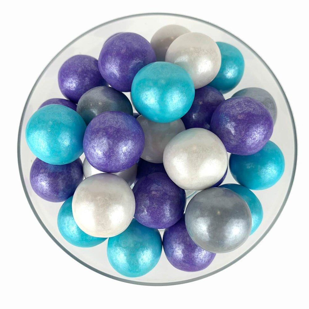 Assorted shimmer gumballs in purple, teal, white, and silver with a glossy finish in a clear bowl.