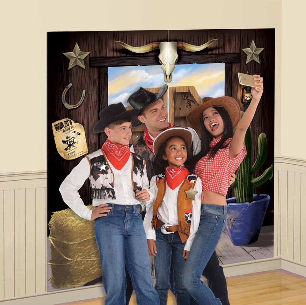 Western-themed backdrop with wood paneling, steer skull, horseshoes, stars, cactus, hay bale, and gold sheriff badge.