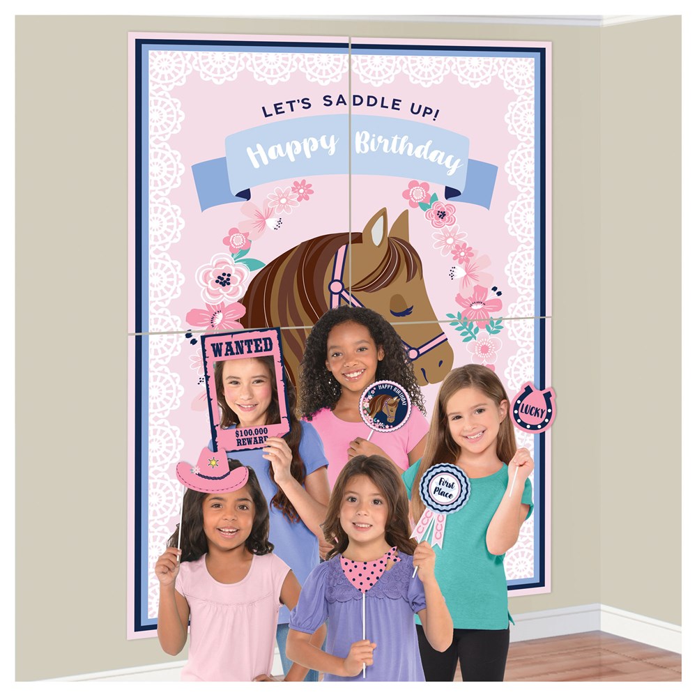 Pink and blue western-themed birthday backdrop featuring horse illustration and floral accents with kids holding cowboy.