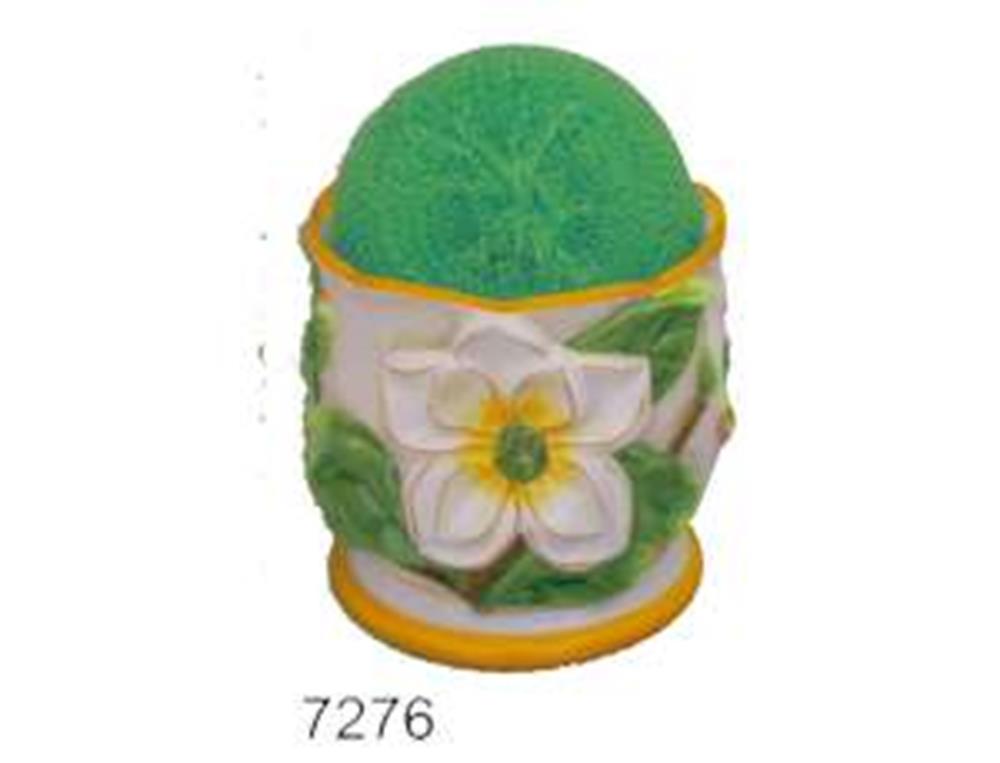 Yellow and green round scourer pad holder decorated with a white magnolia flower and green leaves.