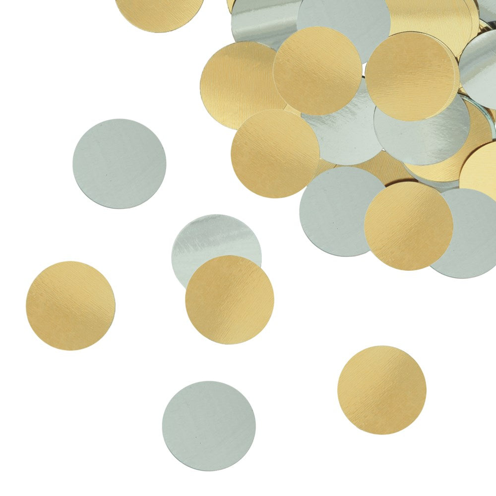 Loose round foil confetti in shiny silver and gold colors scattered on a white background.