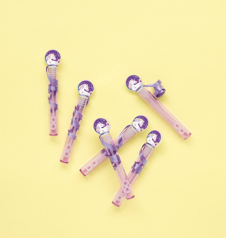 Eight translucent pink bubble tubes with purple wand tops scattered on yellow background.
