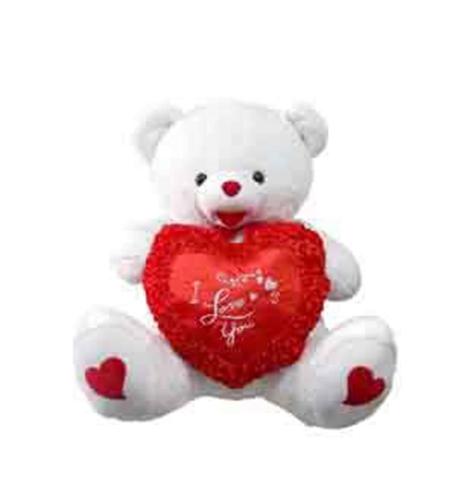 White plush teddy bear holding a red heart pillow with "I Love You" embroidery and small heart details on paws.