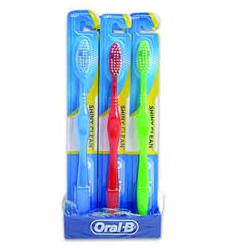 Three Oral-B toothbrushes in red, green, and blue with multicolored bristles in clear plastic packaging and blue branded.