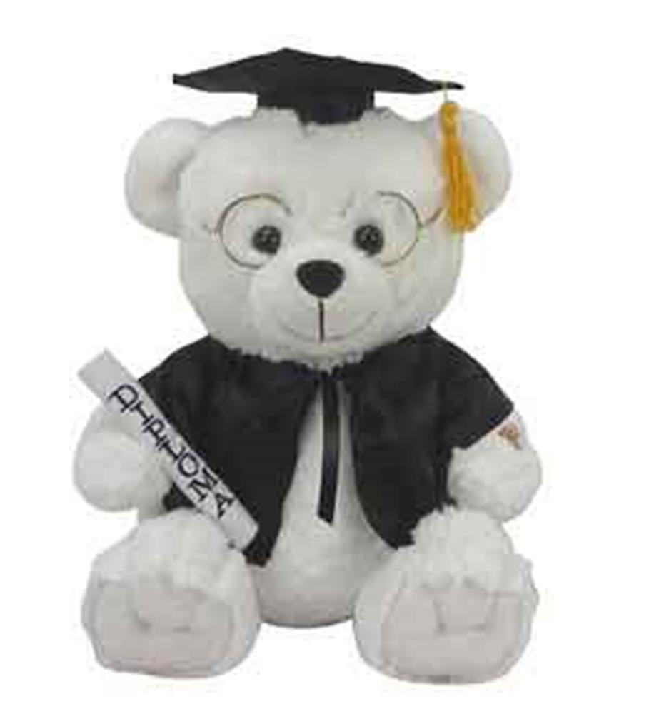White plush bear wearing black graduation cap with yellow tassel and black gown, holding diploma scroll.