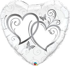 Silver foil heart-shaped balloon with entwined heart designs and decorative swirls.