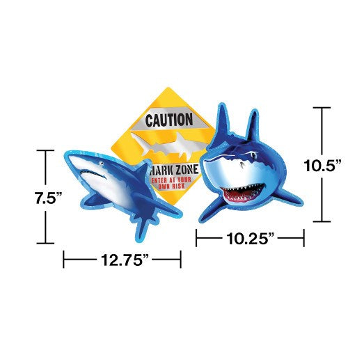 Two inflatable shark pool floats in blue and white with open mouths, positioned beside a yellow caution sign reading "Shark.