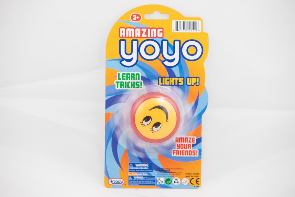 Orange and black 2.5-inch round yo-yo with smiley face design on yellow and blue blister packaging labeled "Amazing YoYo".