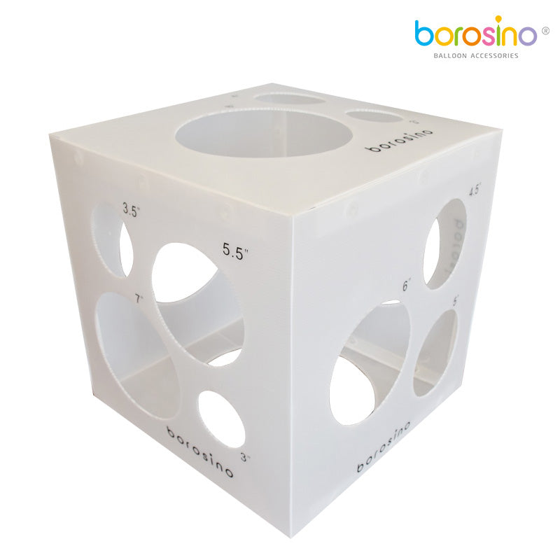 White cube-shaped balloon sizer box with multiple circular holes of varying diameters labeled 2.5" and 5.