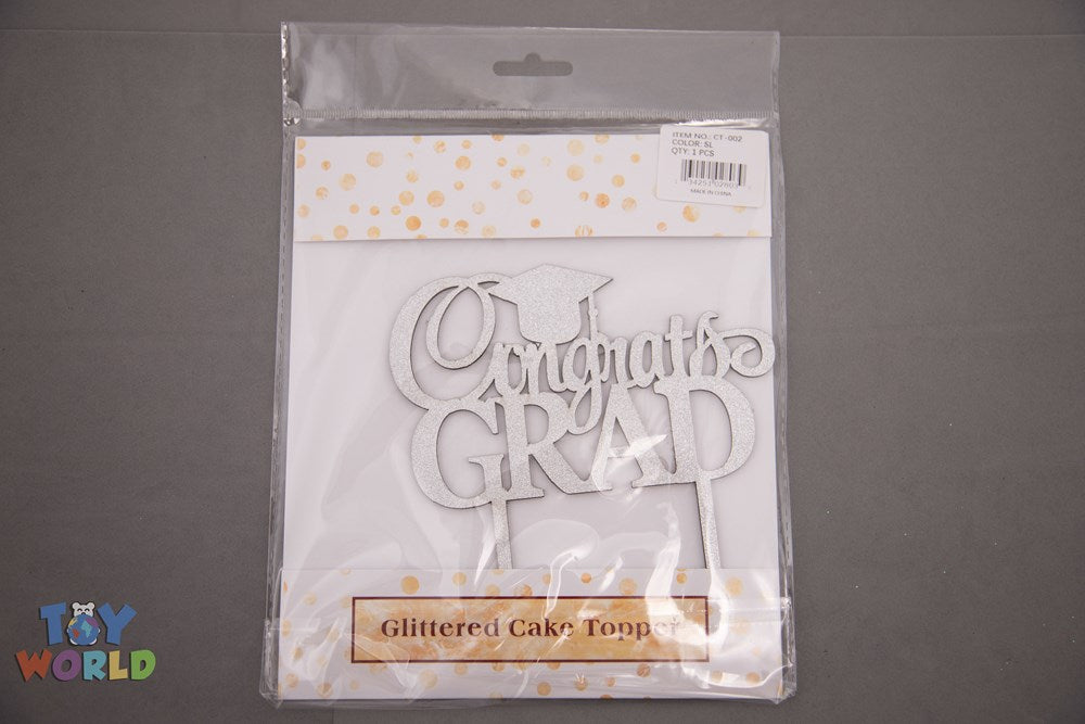 Silver glittered "Congrats Grad" cake topper with cursive and bold lettering in clear plastic packaging.
